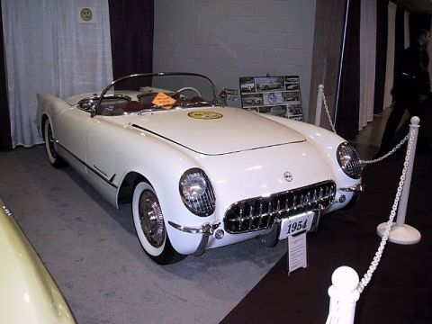 1996 Ford Taurus - A white 1954 Chevrolet Corvette is displayed indoors, possibly at a car show.