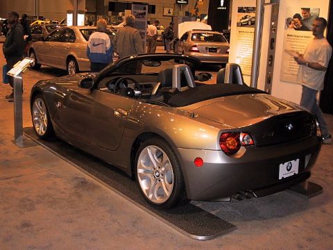 1996 Ford Taurus - A gold BMW Z4 convertible is displayed at an auto show.