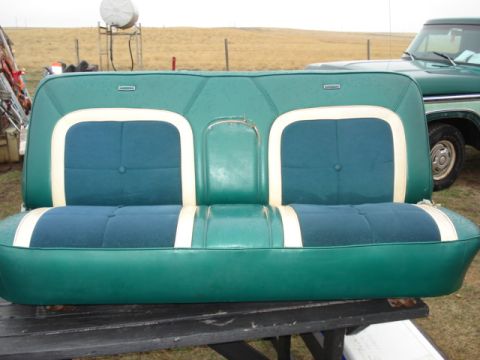 1979 Ford F-150 - A green bench seat with blue fabric inserts and white trim is shown outdoors with a green truck in the background.