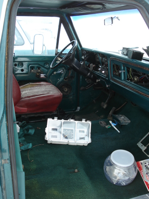 1979 Ford F-150 - The interior of a 1979 Ford F-150 shows a disassembled dashboard with the instrument cluster placed on the carpeted floor.