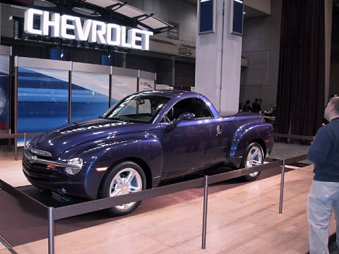 1996 Ford Taurus - Purple Chevrolet SSR pickup truck displayed at an auto show with a Chevrolet sign in the background.