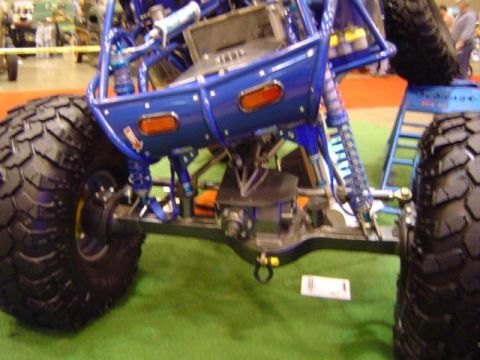 1979 Ford Bronco - A custom-built off-road buggy with large tires and blue suspension components is displayed indoors.