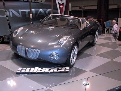 1996 Ford Taurus - A Pontiac Solstice concept car is displayed indoors, likely at an auto show.