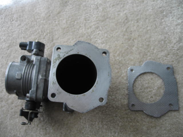 Throttle body assembly and gasket on a carpeted surface