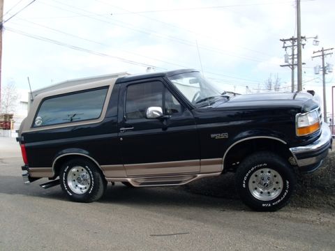 1996 Ford Bronco - This black 1996 Ford Bronco is shown from a three-quarter front angle, highlighting its tan trim and removable top.