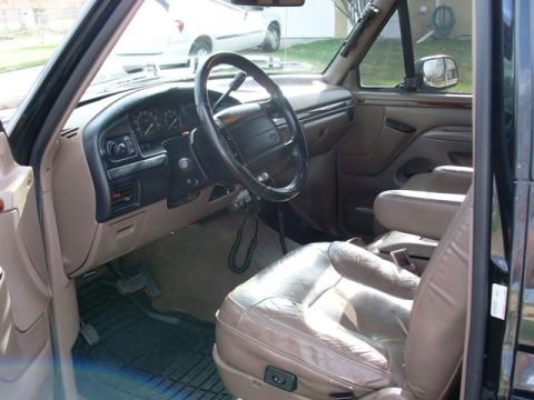 1996 Ford Bronco - The interior of a Ford truck, leather seats and a dashboard with gauges and controls.