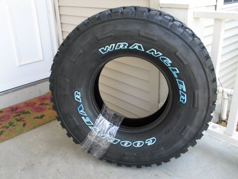 1995 Ford Bronco - A single Goodyear Wrangler tire is taped shut and placed on a porch next to a doormat.