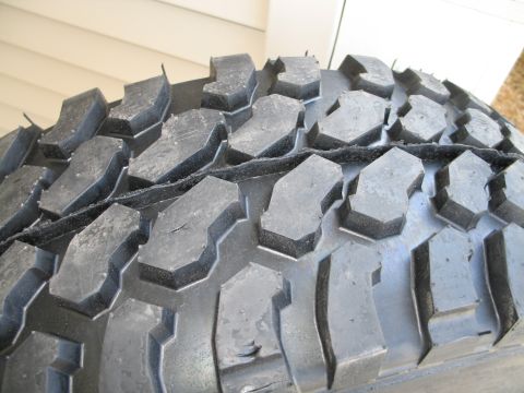 1995 Ford Bronco - The aggressive tread pattern of an off-road tire is shown in detail.