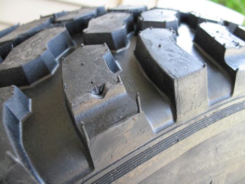 1995 Ford Bronco - This image shows a close-up view of a damaged tire tread, highlighting a cut in one of the rubber blocks.
