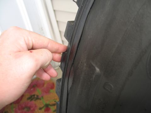1995 Ford Bronco - A hand inspects a tire, revealing its tread and sidewall details.