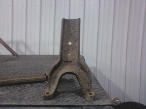 1992 Ford F-350 - A single, weathered metal component rests on a textured surface against a corrugated wall.