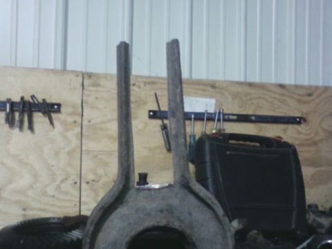 1992 Ford F-350 - A gray metal vehicle part with two upright prongs is shown in a workshop setting.