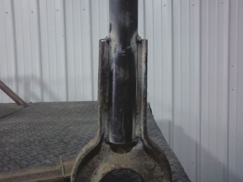 1992 Ford F-350 - Welded metal part shown in detail, situated on a textured surface with a corrugated wall in the background.