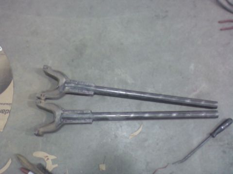 1992 Ford F-350 - Two metal bars with forked ends are visible on a concrete surface, alongside a screwdriver.
