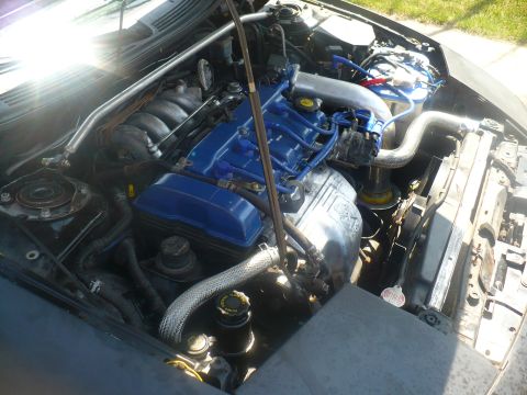 1993 Ford Probe - The engine bay of a car, showing the engine components and associated wiring and hoses.