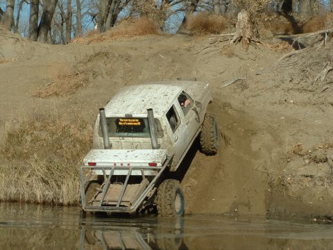 1992 Ford F-350 - This modified Ford F-350 tackles a challenging muddy incline during an off-road excursion.