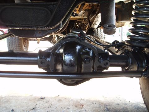 1980 Ford Bronco - Close-up of the front axle assembly and suspension parts on a vehicle.