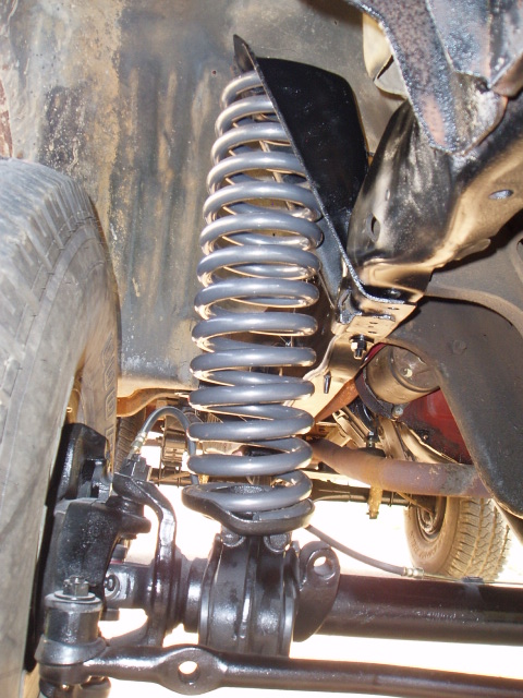 1980 Ford Bronco - Close-up view of the front suspension coil spring and steering linkage on a 1980 Ford Bronco.