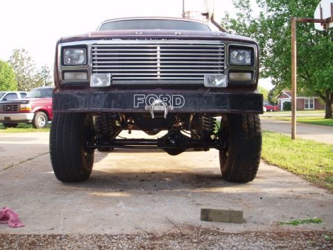 1980 Ford Bronco - Front view of a lifted 1980 Ford Bronco with a custom bumper and grille. Another Ford truck is parked nearby.