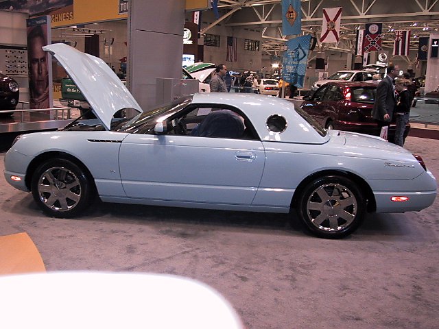 Light blue convertible with hood up, round porthole window on hardtop
