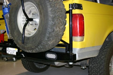 1984 Ford Bronco - Rear view of a yellow Ford Bronco showing its spare tire carrier and aftermarket bumper.
