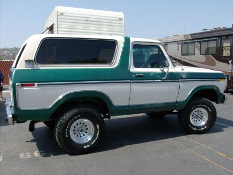 1978 Ford Bronco - This two-tone green and white 1978 Ford Bronco is parked in a lot with RVs and a trailer.