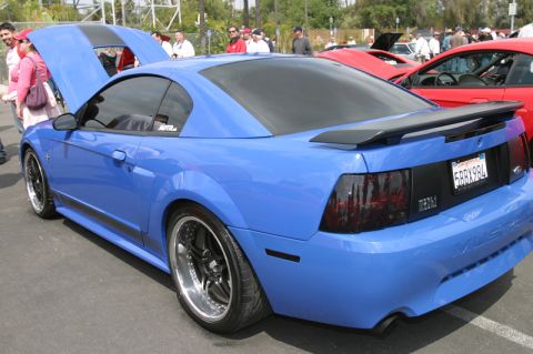 1992 Ford Crown Victoria - A blue Ford Mustang is displayed at a car show, with other vehicles visible in the background.