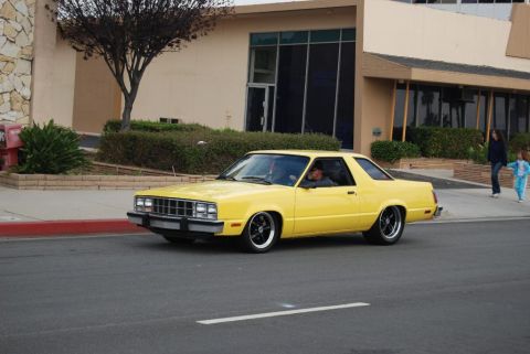 1992 Ford Crown Victoria - A yellow coupe with a distinctive grille and body style is seen driving on a street.