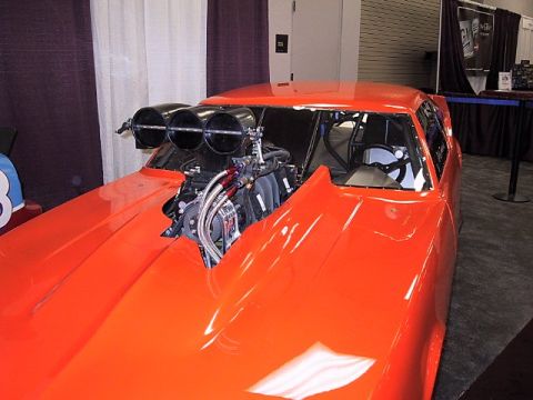 1996 Ford Taurus - Custom drag car with a prominent engine and blower setup, displayed indoors.