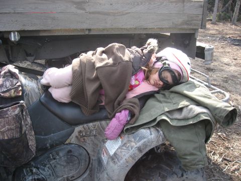 1990 Ford F-250 - A child sleeps soundly on an ATV, bundled in warm clothing, with a truck bed in the background.