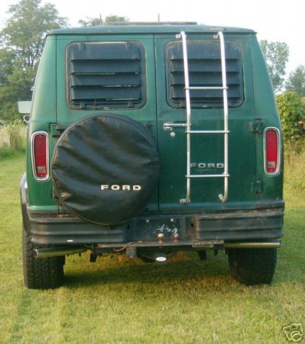 1978 Ford E250 - Rear view of a green 1978 Ford E250 van with a spare tire and a ladder mounted on the back.