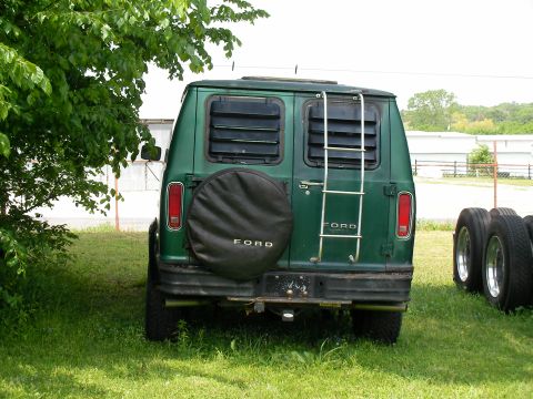 1978 Ford E250 - Rear view of a green 1978 Ford E250 van, a ladder and a spare tire cover with the Ford logo.