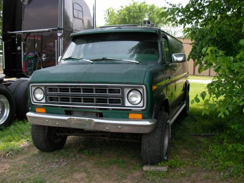 1978 Ford E250 - Front 3/4 view of a green 1978 Ford E250 van parked next to a semi-truck.