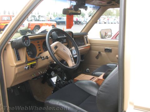1968 Ford Mustang - The interior of a Ford Bronco II shows custom gauges and a wooden console, with other vehicles visible outside.