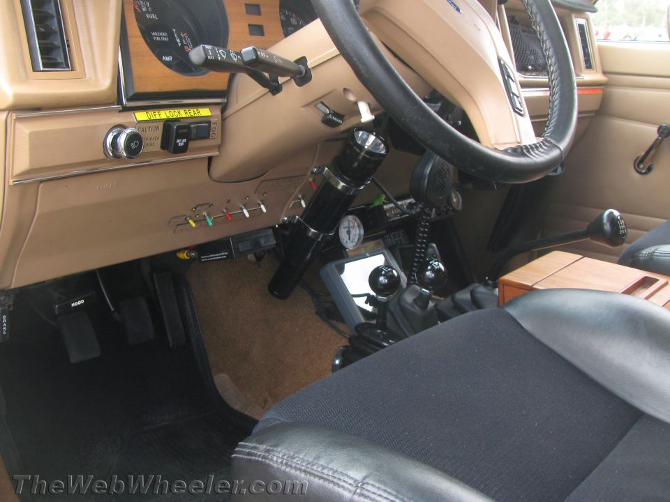 Vehicle interior with tan dashboard, black steering wheel, and floor shifter