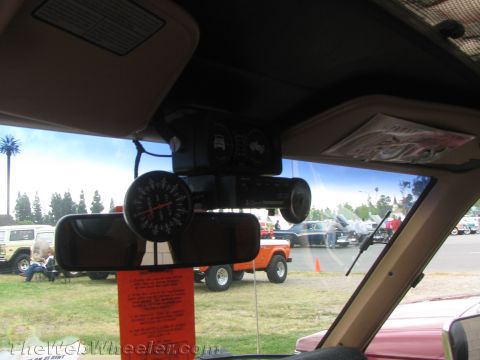1968 Ford Mustang - A gauge and mirror are mounted inside a vehicle, with other cars visible through the windshield.