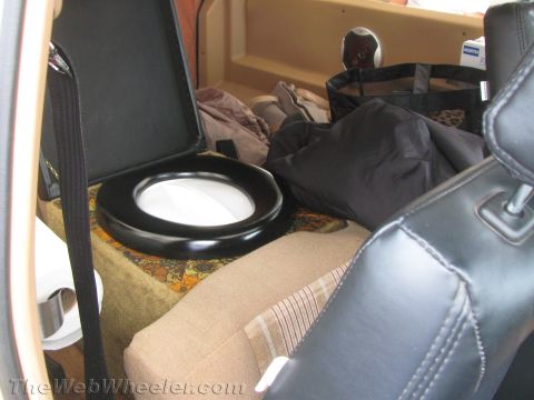 1968 Ford Mustang - The cargo area of a vehicle is filled with various items, including luggage and a portable toilet seat.