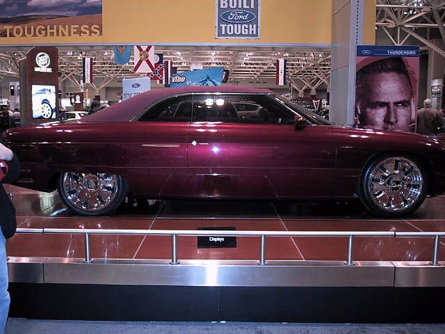Custom coupe with deep purple metallic paint and chrome wheels on display