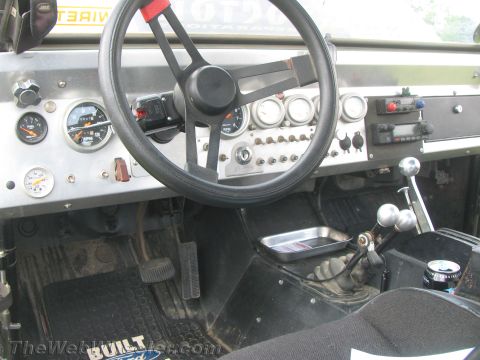 1968 Ford Mustang - The interior of this vehicle features a custom dashboard with multiple gauges and a manual transmission shifter.
