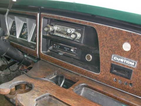 1978 Ford E250 - The interior of a 1978 Ford E250 shows the dashboard with its woodgrain trim and various controls.