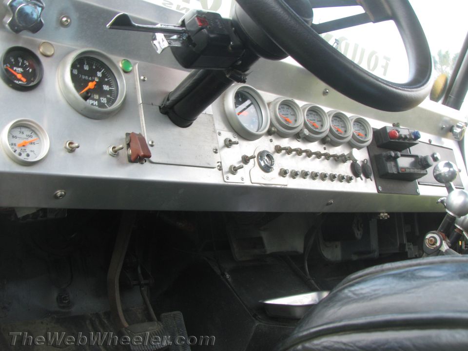 Custom dashboard with fuel, oil pressure, and speedometer gauges, plus numerous switches and a chrome shifter