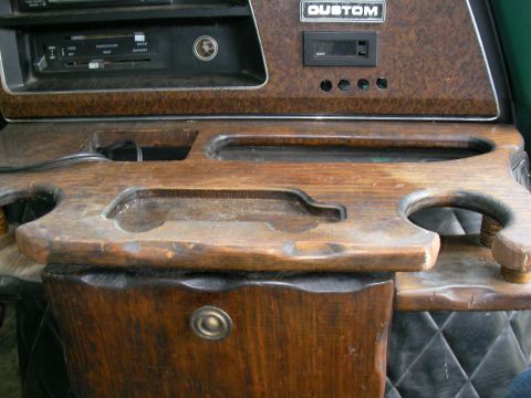 1978 Ford E250 - Interior view of a custom wooden dashboard with a 'CUSTOM' badge and cup holders.