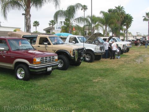 1968 Ford Mustang - Several Ford trucks and SUVs are parked in a grassy area, with some owners gathered around the vehicles.