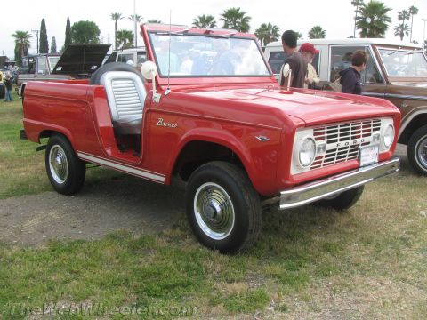 1968 Ford Mustang - A red first-generation Ford Bronco convertible is parked outdoors with other vehicles visible in the background.