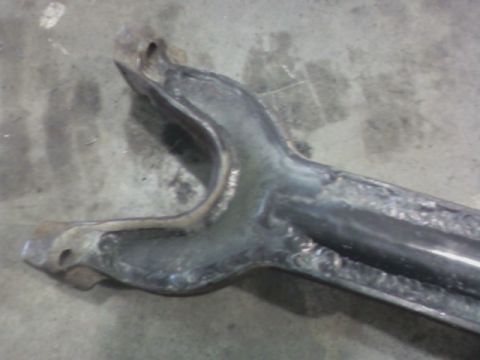 1992 Ford F-350 - A close-up view of a metal suspension component, likely from a truck, resting on a concrete floor.