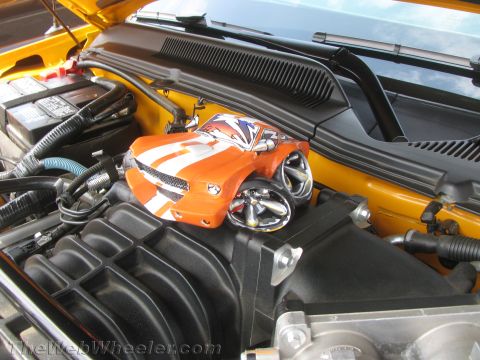 1968 Ford Mustang - A toy car is placed on the engine of a yellow vehicle.