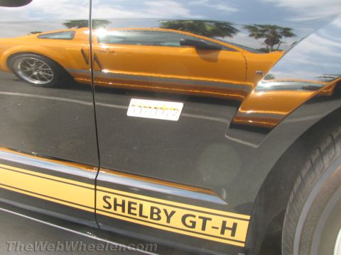 1968 Ford Mustang - A black Shelby GT-H Mustang is shown with a reflection of an orange Mustang in its side panel.