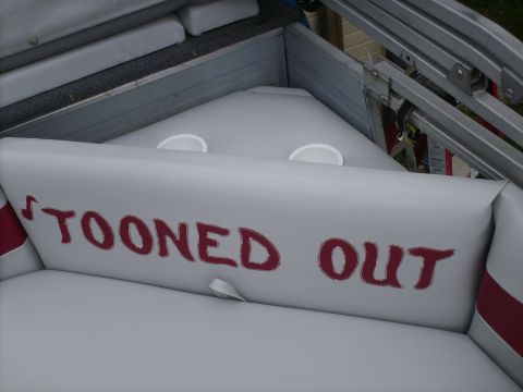 Boat interior with red text reading 'TOONED OUT' on a cushion