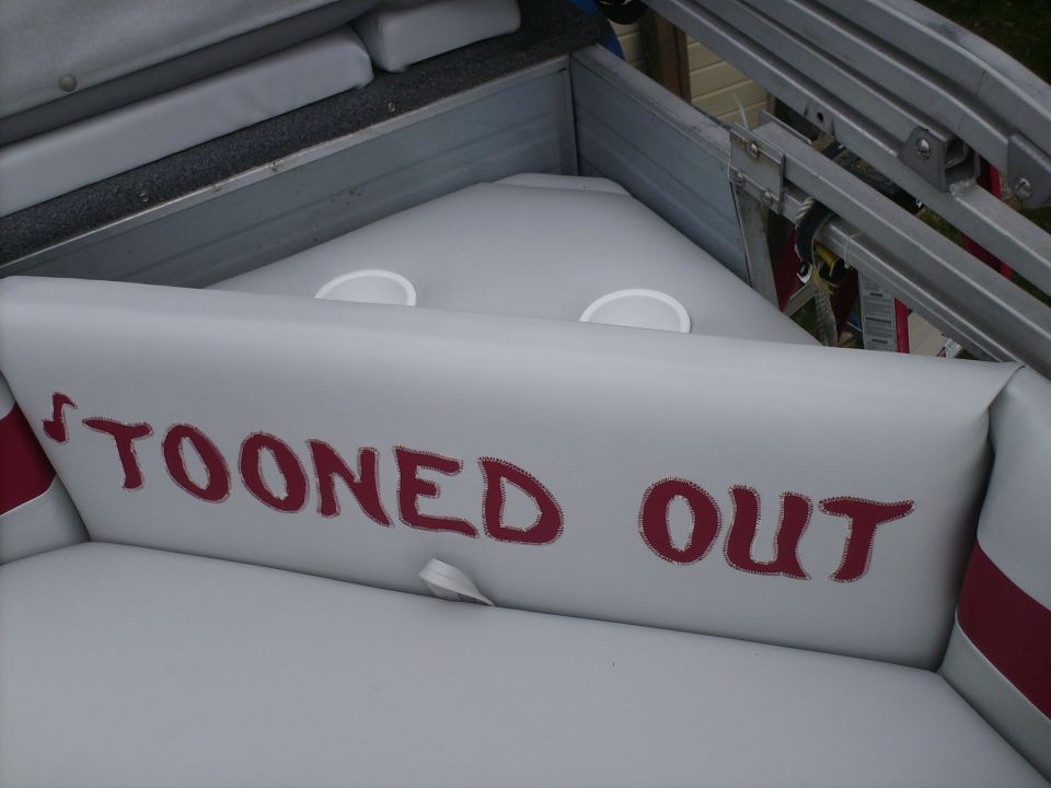 Boat interior with red text reading 'TOONED OUT' on a cushion