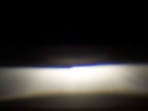 1993 Ford Probe - A bright headlight beam illuminates the darkness, with a subtle blue hue visible at the top edge.